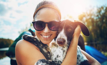 Téléchargez les photos : Portrait, woman and dog with love for camping in forest, sunshine and bond for smile by support of adventure time. Happy, female person and puppy as pet with care, hug or relax in summer journey. - en image libre de droit