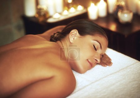 Téléchargez les photos : Relaxing, woman and zen in salon for treatment, massage and wellness with cosmetics. Candles, luxury and sleeping with peace after aromatherapy, deep tissue and body care for glow and beauty. - en image libre de droit