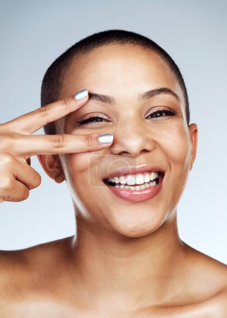 Beauty, peace sign on eye and portrait of black woman in studio on blue background for natural aesthetic. Cosmetics, skincare or smile and face of happy model satisfied with dermatology or vitamin c.
