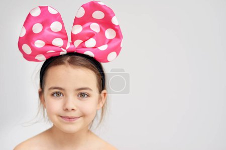 Photo for Happy, young girl and pink bow in hair for party or event celebration with mockup isolated in studio. Smile, female child and alice band for trendy fashion and aesthetic accessory on white background. - Royalty Free Image