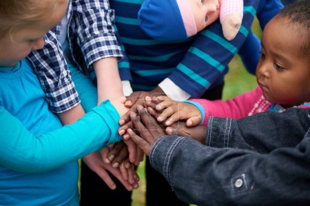 Händeschütteln und sich gemeinsam mit Kindern im Park für Humanität, Wohltätigkeit und Aktivismus engagieren. Stapeln, Unterstützung und Teamarbeit mit Frauen oder Kindern im Freien oder in der Natur für soziale Arbeit.