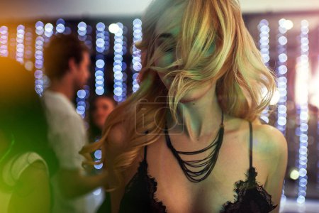 Foto de Dance, lights and woman in nightclub for fun, music or happy weekend at social event. Nightlife, energy and girl at trendy disco club with friends, smile and celebration at party with youth culture - Imagen libre de derechos