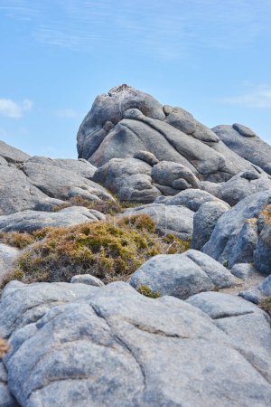 Photo for Mountain, rocks and texture in nature for landscape with blue sky background, beauty and summer for adventure in Greece. Journey, outdoor and explore view for road trip, stone and geology formation. - Royalty Free Image
