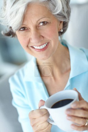 Téléchargez les photos : Femme âgée, portrait et thé à la maison le week-end, satisfaction et confiance pour la paix ou le calme. Femme, boire du café et sourire à la retraite, bien-être et heureux dans l'appartement pour se détendre. - en image libre de droit