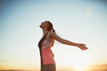 Photo for Woman, happy and freedom outdoor with fitness for exercise success, workout victory and celebration. Athlete, person and hand gesture in nature with blue sky, lens flare and training achievement. - Royalty Free Image