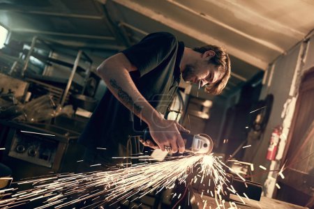 Photo for Handy man, sparks and angle grinder for welding at night in workshop for repair and maintenance. Home renovation, creativity and construction worker or carpenter with project for small business. - Royalty Free Image