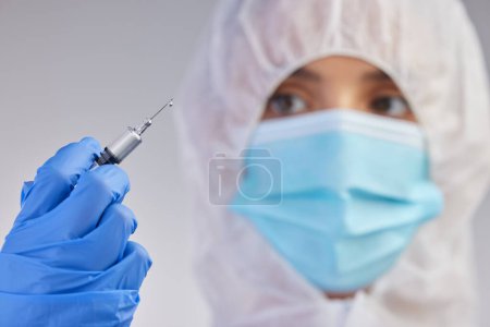 Photo for Ppe, nurse and needle in white studio background for vaccination, hospital safety and medical practice. Danger, healthcare worker or female person in scrubs for viral defence, wellness and protection. - Royalty Free Image