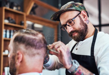 Téléchargez les photos : Hair care, client and man in barbershop with comb, cut and tools for trendy hairstyle trim at small business. Style, barber and customer in chair for grooming service, haircut skills and clean shave. - en image libre de droit