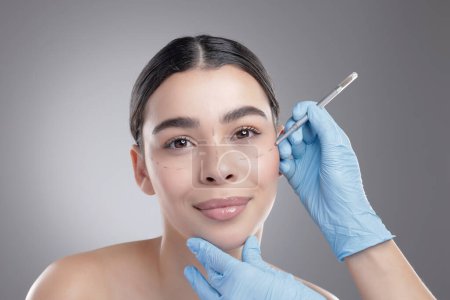 Photo for Woman, portrait and cheek injection in studio, skincare and cosmetic service on gray background. Female person, needle and plastic surgery or botox treatment, syringe and implant or beauty filler. - Royalty Free Image