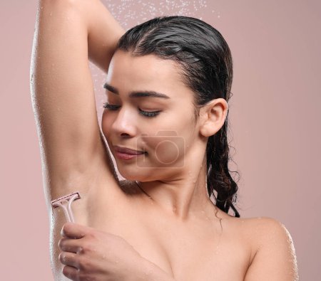 Photo for Woman, razor and shave armpit in studio, pink background and happy model with water droplets. Grooming, hair removal and maintenance for body care, hygiene and wellness for skincare and clean. - Royalty Free Image