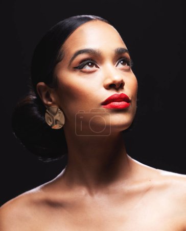 Foto de Woman, thinking and makeup for beauty in studio on dark background with hairstyle, glow skin and earring. Female person, confidence and satisfied with fresh, elegant and cosmetics for fashion. - Imagen libre de derechos