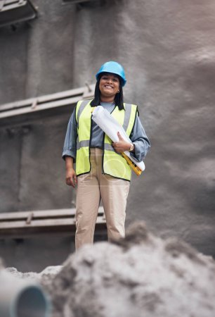 Photo for Woman, portrait and happy at construction site with blueprint, documents and helmet for safety at job. Person, engineer or contractor with paperwork, plan and water level for architecture in India. - Royalty Free Image