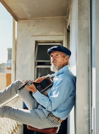 Senior, man and artist with acoustic guitar for playing with retired musician on balcony in town for memories. Creative, elderly and proud of accomplishments with blues or folk song in urban Italy