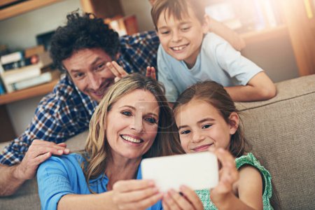 Glückliche Familie, entspannen und Selfie mit Friedenszeichen für Erinnerung, Bild oder Bindung zusammen auf dem Sofa zu Hause. Mama, Papa und kleine Kinder mit Lächeln für Fotos, Aufnahmen oder Momente auf der Wohnzimmercouch.