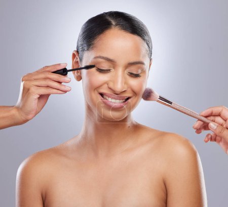 Woman, makeup brush and studio for beauty, hands and cosmetics on gray background. Cosmetology, smile and mascara for facial treatment, tools and foundation for application or contour powder.