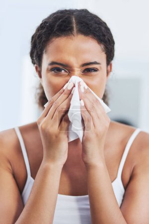 Portrait, tissue and woman with sneeze, sick and cold with disease, home or health crisis in living room. Apartment, person or girl with congestion, allergy or flu season with viral infection or pain.