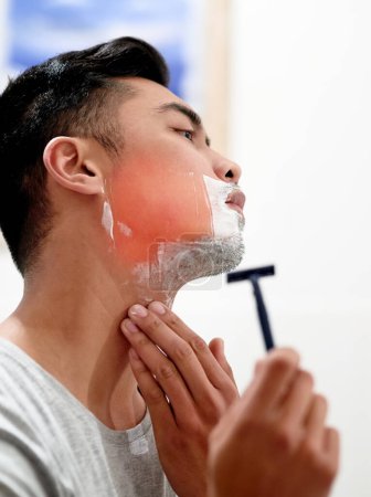 Razor, man and shaving face with pain, burn or red glow in bathroom with cosmetic on morning routine in home. Cream, beard and cut for skincare, grooming or clean in profile with inflammation injury.