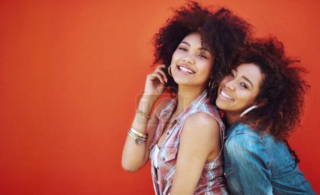 Women, friends and portrait or fashion in studio with casual style, trendy outfit and mockup space on red background. Girls, people and smile in city with streetwear, afro and pride in edgy clothes.