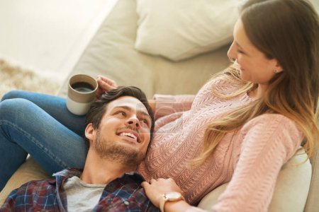 Photo for Coffee, relax or happy couple on sofa in home living room together with love, support or trust. Talk, above or romantic man bonding with woman with loyalty, wellness or smile in marriage commitment. - Royalty Free Image