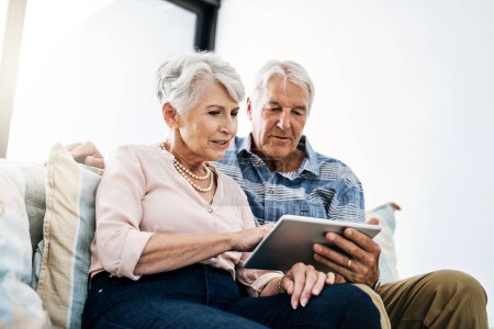 Tablet, browsing and mature couple in living room in house for online movie streaming on website. Subscription, tech savvy and elderly empowerment with networking, social media and relax in home
