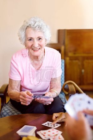 Poker, portrait and senior woman with friends playing cards in retirement home together. Assisted living, community or games with happy elderly people in apartment for bonding, fun or leisure.