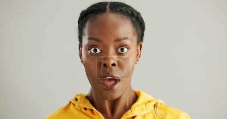 Überraschung, Porträt und schwarze Frau im Studio mit omg für Ankündigung, Klatsch oder Fake News auf grauem Hintergrund. Weite Augen, Emoji und eine Person mit Reaktion auf geheime, wow oder unerwartete Enthüllungen.