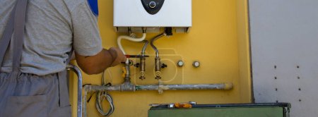 Téléchargez les photos : Image d'un plombier en train de réparer et d'installer une chaudière à gaz. Bannières horizontales - en image libre de droit