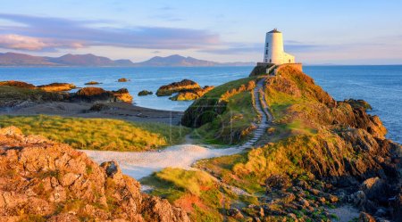Photo for Twr Mawr lighthouse, an iconic landmark on Anglesey island, panoramic view on sunset, Wales, United Kingdom - Royalty Free Image
