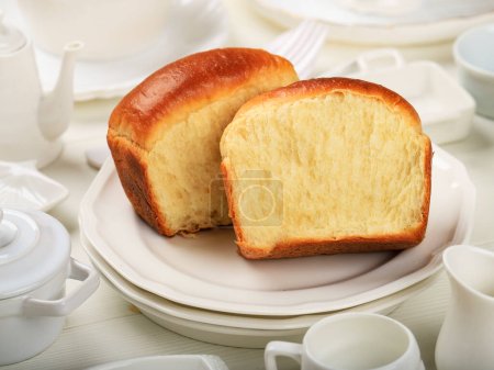 Foto de Pan blanco esponjoso suave hecho en casa, pan de leche japonés. En la placa blanca - Imagen libre de derechos