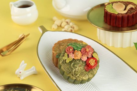 Téléchargez les photos : Gâteau de lune de thé vert avec de la poussière dorée sur fond jaune. Concept pour la fête de la mi-automne avec espace de copie pour le texte. Caractère chinois est Fu signifie Fortune - en image libre de droit