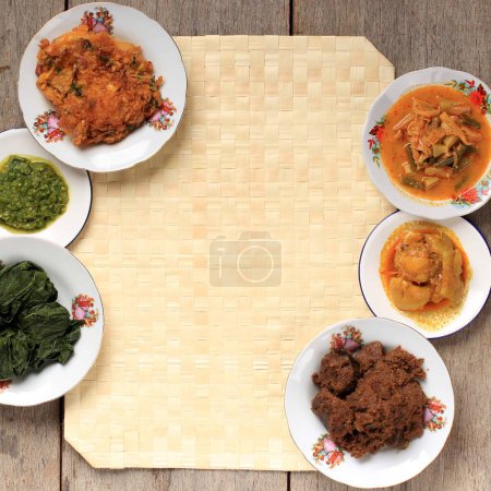 Photo for Selected Focus Various Menu of Padang Restaurant. Homemade Masakan Padang or Minang Cuisine on Rustic Background with Copy Space at the Center. - Royalty Free Image
