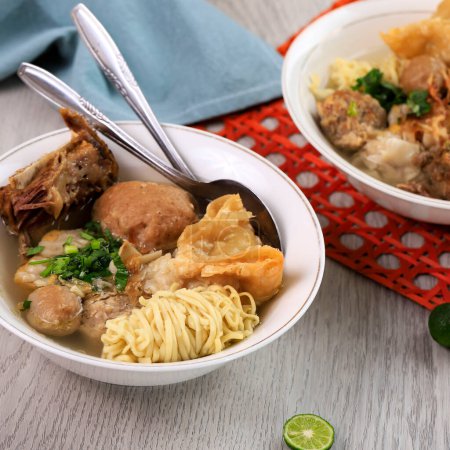Foto de Bakso Malang Komplit, sopa de albóndigas con varios platos secundarios como fideos, frito Shiumay o costillas. Servido sobre la mesa (Bakso Iga) - Imagen libre de derechos
