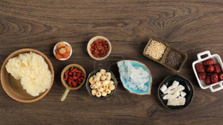 Téléchargez les photos : Les ingrédients de base de la gomme de pêche (Tao Jiao) disposés sur une table en bois - en image libre de droit
