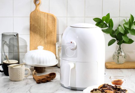 White Mini Air Fryer for Cooking WIthout Oil. Copy Space for Text. COncept of White Kitchen Healthy Cooking