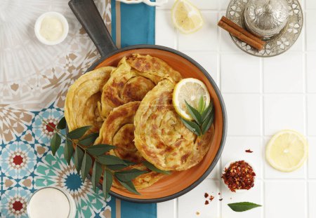Photo for Roti Parata or Roti Canai with Lamb Curry Sauce and Lemon, Popular Malaysian Breakfast - Royalty Free Image