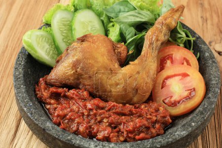 Photo for Ayam Penyet or Penyetan Ayam, Fried Chicken with Spicy Sambal Chilli Paste. Popular Indonesian Street Food, Usually Served with Rice - Royalty Free Image