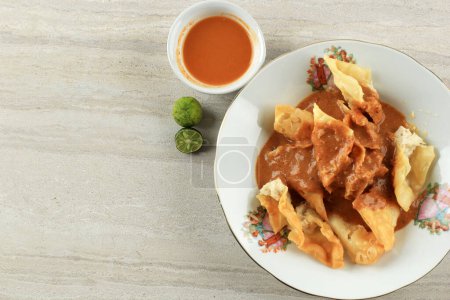Téléchargez les photos : Batagor Baso Tahu Goreng, Deep Fried Fish Dumpling with Peanut Sauce and Soy Sweet Sauce. Popular Street Food from Bandung - en image libre de droit