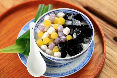 Chinesisches Dessert Schwarzes Grasgelee mit Tarokugeln, serviert mit süßer Kokosmilch. Cincau Hitam 