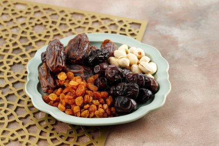 Foto de Varios Snack para el dulce Takjil Iftar Mes musulmán del Ramadán, Pistacho, Fechas Fruta, y pasas de uva doradas. - Imagen libre de derechos