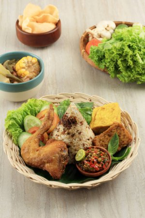 Photo for Nasi Tutug Oncom. Traditional Sundanese Meal of Rice Mixed with Fermented Soybean Accompanied with Chicken, Sambal, Tofu, and Tempeh - Royalty Free Image