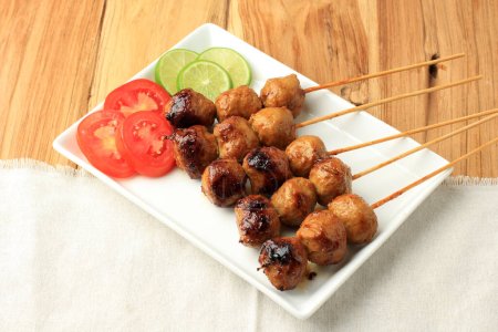 Photo for Bakso Bakar, Grilled Meatball Served with Skewer. Meatballs Coaed with Soy Sauce and Grill, Favorite Indonesian Street Food - Royalty Free Image