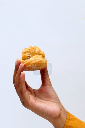 Photo for Female Hand Hold Vanilla Custard Soes Choux on White Background. Copy Space for Text - Royalty Free Image