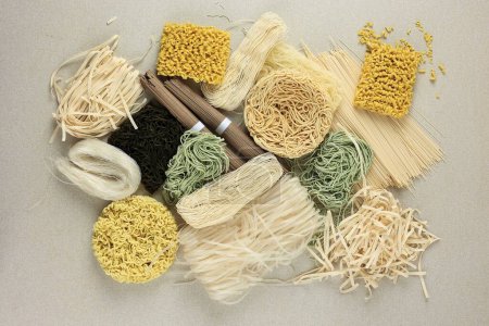Verschiedene Arten rohe asiatische Nudeln, Soba, Ramen, Ramyeon, Misua, Char Kway Teow, Gemüseeiernudel, Somen. Blick von oben auf den Sahnetisch 