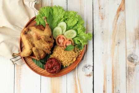 Foto de Ayam Goreng Kremes. Plato de pollo frito popular de Yogjakarta, pollo entero frito profundo con patatas fritas sazonadas - Imagen libre de derechos