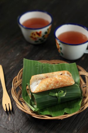 Photo for Serabi Notosuman Solo. Traditional Pancakes from Solo, Central Java. Made from Rice Flour and Coconut Milk, Cooked on Traditional Earthy Pan. Rolled with Banana Leaf. - Royalty Free Image