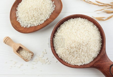 Téléchargez les photos : Grain de riz blanc japonais sur bol en bois, sur table blanche - en image libre de droit
