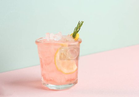 Pink Alcoholic Rose Lemon Beverage or Lemonade, Cocktail with Rosemary and Lemon Slice