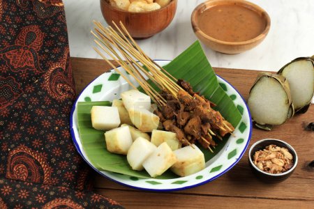 Photo for Sate Padang. Spicy Beef Satay from Padang, West Sumatra. Served with Spicy Curry Sauce and Rice Cake or Ketupat - Royalty Free Image