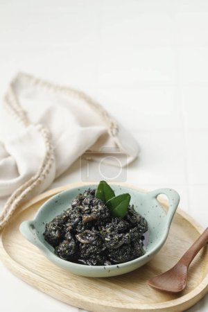 Foto de Sopa negra de calamar o Tumis Cumi Hitam. Remover el calamar frito en tinta negra, comida tradicional indonesia - Imagen libre de derechos