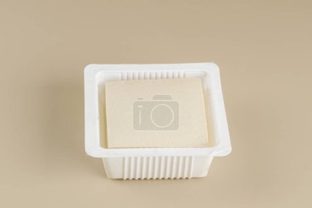 Silk Smooth Tofu or Tahu Sutra on Plastic Supermarket Packaging. Isolated on Cream Background